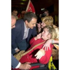 Zapatero saluda a una joven simpatizante en silla de ruedas