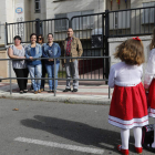 Dos pequeñas que acuden al comedor del Antonio Valbuena posan en el colegio con un grupo de madres y padres