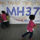 Un grupo de niños escribiendo mensajes esperanzadores para los familiares de las personas que desaparecieron en el vuelo MH370, de la compañía Malasya Airlines, en mayo del 2014.