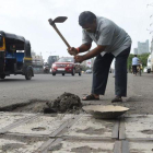 Dadarao Bilhore arreglando uno de los numerosos baches en las carreteras de Mumbai, India.