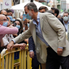 El rey saluda a un hombre con el codo en la calle, junto a la reina Letizia. BELESTEROS