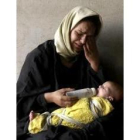 Un mujer da un biberón a su hijo tras sobrevivir ayer a un ataque aliado
