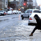 Una mujer cruza una calle nevada en Nueva York.
