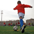 Un niño se apresta a chutar durante un partido de fútbol base.