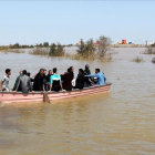 Iranís de la provincia de Golestan, anegada por las lluvias, en una barcaza a finales de marzo.