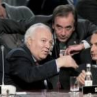 Moratinos explica a Zapatero un tema con Alonso de testigo en un receso de las reuniones de la Otan