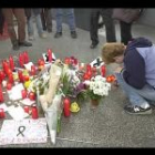 Un ciudadano se arrodilla ante las ofrendas de flores y velas encendidas colocadas en las inmediaciones de la estación de tren de Atocha en señal de duelo y recuerdo de las víctimas de los atentados.