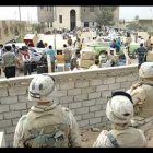 Marines observan a iraquíes saqueando un edificio gubernamental en un suburbio de la capital iraquí.