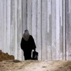Una mujer palestina camina hacia la barrera de seguridad levantada por el ejército israelí
