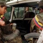 Dos guerrilleros de las Farc cargan provisiones en un vehículo