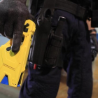 Un agente sostiene una pistola táser.