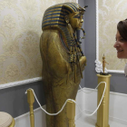 Una mujer contempla una pieza del Museo-Liceo Egipcio; a la derecha, la réplica del sarcófago de Tutankamon.