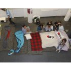 Los primeros jóvenes que llegaron a Educación preparan sus sacos de dormir para pasar la noche en el recibidor