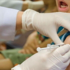 Una enfermera inyectando a un niño una vacuna, en una foto de archivo.