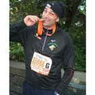 El atleta leonés Urbano Gonzálezmuerde la medalla que le entregó la organización.