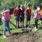 La concejala Ana Franco observa a un grupo de niños plantar un árbol en el Coto Escolar. CÉSAR