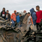 Unos palestinos permanecen junto a los restos de un automóvil destruido tras un ataque aéreo israelí en Khan Yunis, en el sur de la Franja de Gaza.