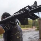 Un miembro de las FARC entrega un fusil de asalto.