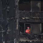 Un bombero inspecciona los restos de la Torre Grenfell, el edificio de apartamentos de 24 plantas en North Kensington, que se incendió el pasado sábado.