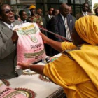 Mugabe entrega un saco de maíz a una simpatizante del partido Zanu