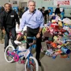 Bush lleva una bicicleta durante su visita a un centro de colecta de juguetes para niños necesitados