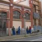 Varios alumnos pintan la fachada principal de la escuela