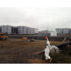 Un trabajador camina cerca de los tanques de agua en la planta nuclear de Fukushima, el pasado mes de junio.