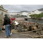 Dos vecinos observan los restos arrastrados a la zona baja de la ciudad tras las fuertes lluvias.