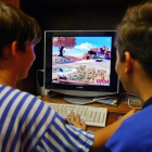 Dos niños, ante una pantalla de ordenador.