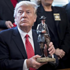 Trump sostiene una figura con la que fue obsequiado en la reunión que mantuvo ayer con los 'sheriffs' del país.