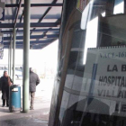 Tres viajeros esperan iniciar su viaje en el andén de la estación bañezana.