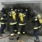 Los Bomberos proceden a entrar al garaje desde donde sale un intenso calor y humo negro