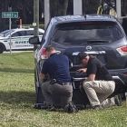 Agentes de policía se protegen tras su vehículo durante el tiroteo en el banco de Florida, este miércoles.