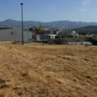 El solar que ocupará la nueva guardería municipal con los edificios del Campus del Bierzo al fondo