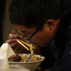 Un hombre asiático comiendo.