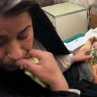 Una mujer iraquí ayuda a su hijo, que tiene leucemia, en un hospital de Bagdad