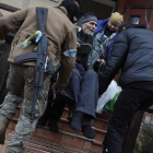 Personal de Defensa Territorial de Ucrania ayuda a evacuar a las personas mayores de un refugio en la ciudad de Irpin. ATEF SAFADI