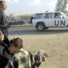 Ciudadanos iraquíes observan un coche que transporta a los expertos de la ONU cerca de Bagdad