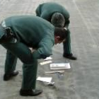 Dos miembros de la Guardia Civil inspeccionan el trozo de meteorito