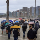Decenas de personas pasean este domingo por la playa de San Lorenzo. ALBERTO MORANTE