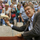 Alberto Núñez Feijóo saluda a varios simpatizantes que le regalaron una tarta por su cumpleaños, durante la campaña cara a las elecciones gallegas.