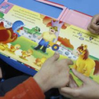 Un educador atiende mediante un juego a un niño con problemas de comunicación.
