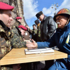 Un anciano habla con un oficial ucraniano en un centro de reclutamiento al aire libre en Kiev, ayer.