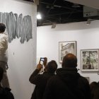 El artista leonés Daniel Verbis pintando en Arco y dos empleados transporando una obra.