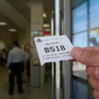 Un usuario muestra el número 518 de la cola de espera, ayer a las doce y media en Correos.