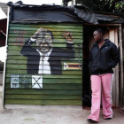 Una joven pasa ante un mural de Mugabe en Harare.