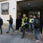 Agentes de la policía científica salen del edificio donde se ha producido el suceso