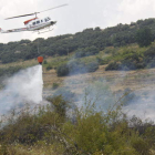 Un helicóptero arroja agua sobre el foco, posiblemente intencionado, que se inició ayer en la Ercina. CAMPOS