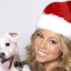 Una imagen de archivo de Mariah Carey, en una fotografía navideña, posando junto a un perro en el 2013.