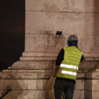 Anti-government protester scrawls graffiti that reads  Macron resign   on the wall of the Arc de Triumph in central Paris.